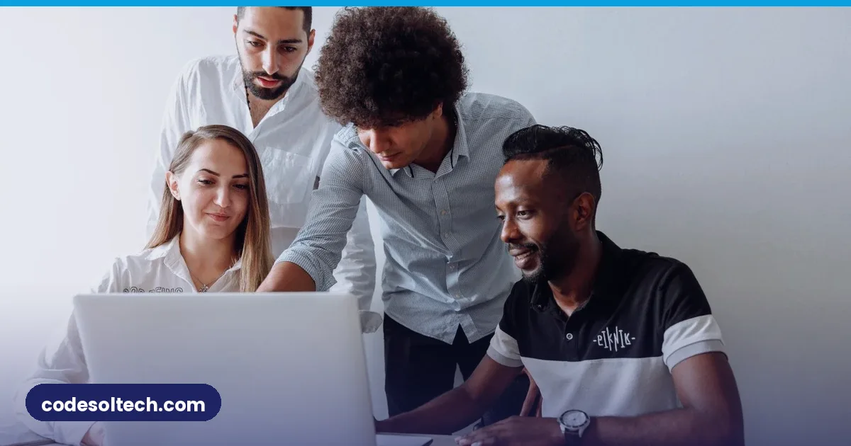 Team collaborating around a laptop in a modern office