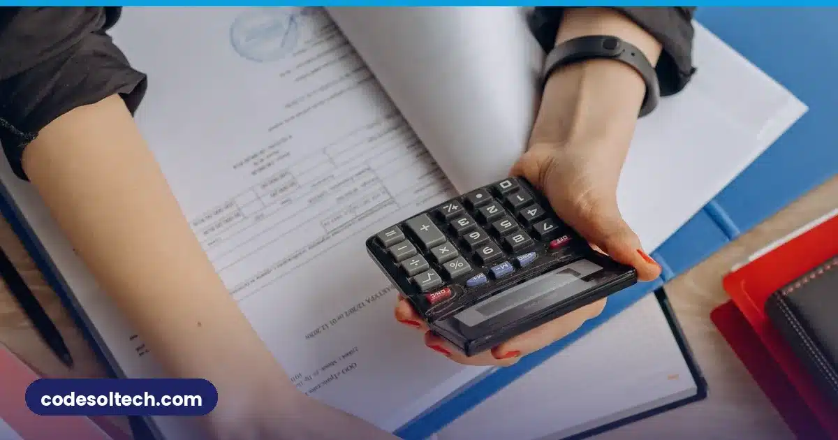 Person calculating business costs with calculator and laptop